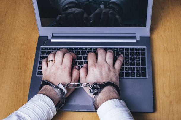 Unas manos encadenadas escriben en un ordenador